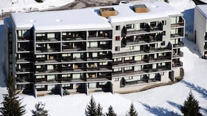 A multi-story hotel with balconies and a snow-covered roof. - Comfortable Apartment Resort Center Balcony Covered Parking (Araches-la-Frasse)