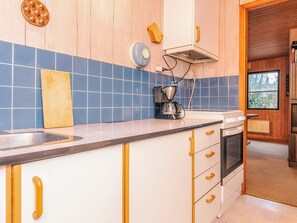 A kitchen with a sink, stove, and coffee maker. - 4 Person Holiday Home in Hals (Hals)