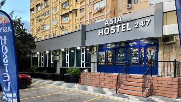Un edifici amb un cartell que diu "ASIA HOSTEL 24/7".