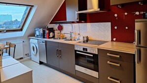 Une cuisine moderne équipée d’un four Bosch, d’un lave-vaisselle et d’un crédence recouverte de carreaux rouges.