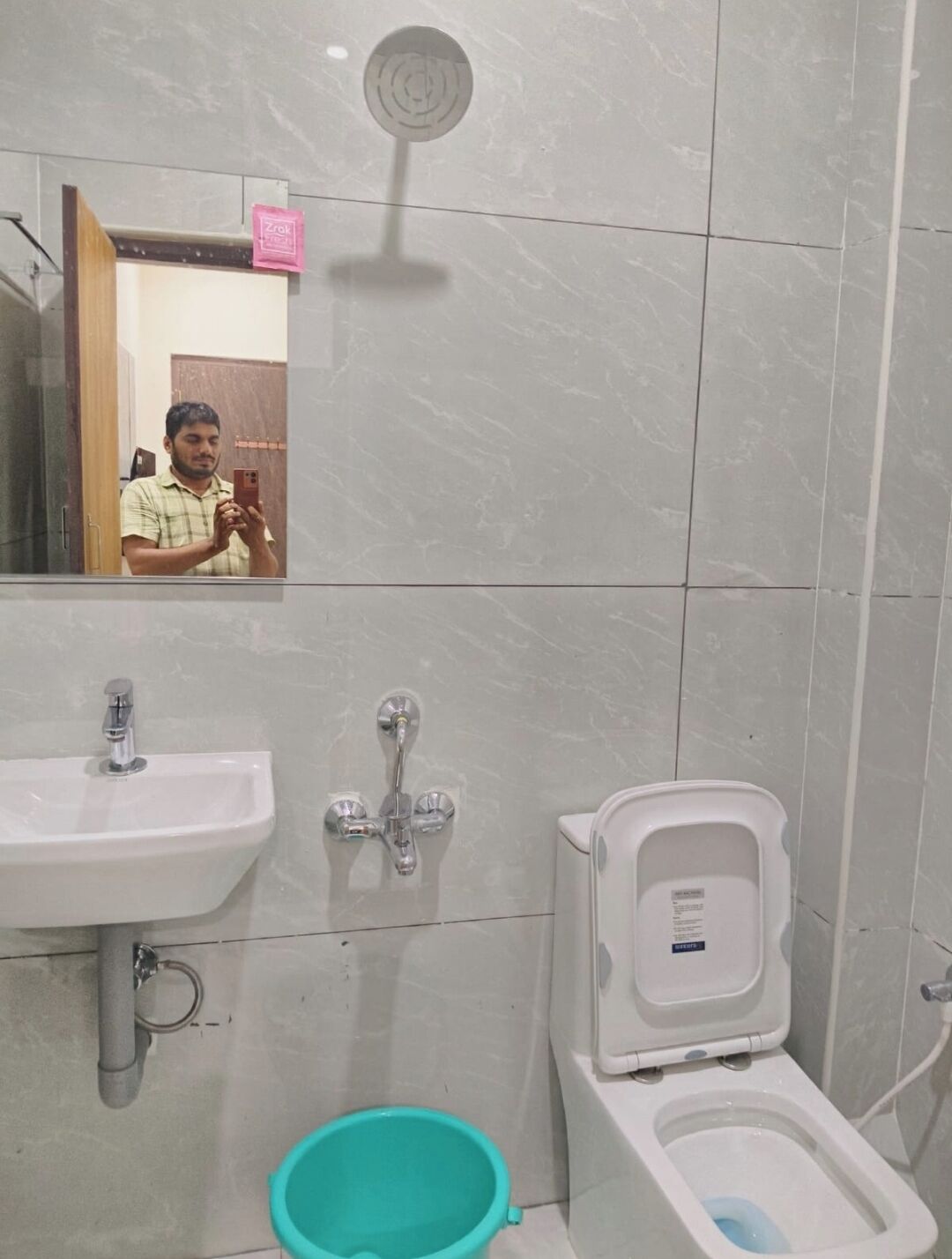A bathroom with a sink, a toilet, and a mirror.