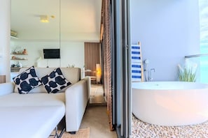 Ein modernes Interieur mit einer Couch, einer großen Badewanne und einem Fernseher.
