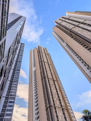 A tall building with a modern design, featuring a prominent vertical structure and a series of windows. - Zire Wongamat | Beachfront Seaview with Bathtub (Pattaya)
