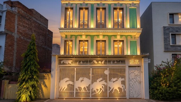A multi-story building with balconies, a gated entrance with decorative cutouts, and a sign with the letter 'M'. - The Collectors Loft-A Luxury Private Suit Near Jaipur City Center - Two-Bedroom Apartment (Jaipur)