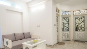 A living room with a sofa, a coffee table, and decorative doors. - The Collectors Loft-A Luxury Private Suit Near Jaipur City Center - Two-Bedroom Apartment (Jaipur)