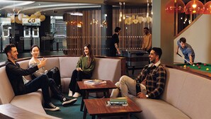 Un moderno espacio de lounge con sofás, mesas y una mesa de billar.