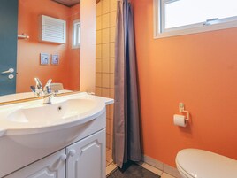 A bathroom with a white sink, a toilet, and a shower curtain.
