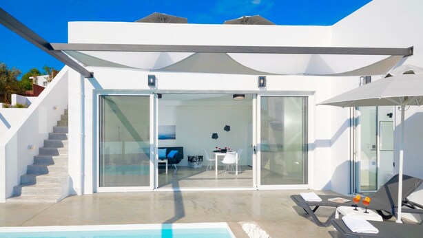 A modern pool area with a clear view of the interior, including a dining area and a seating space with a table and chairs. - Villa Paradiso 1 With Private Pool (Malevizi)