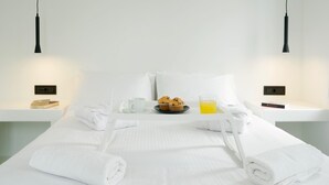 A neatly made bed with white linens, a tray with muffins and juice, and a book on the bedside table. - Villa Paradiso 2 With Private Pool (Malevizi)