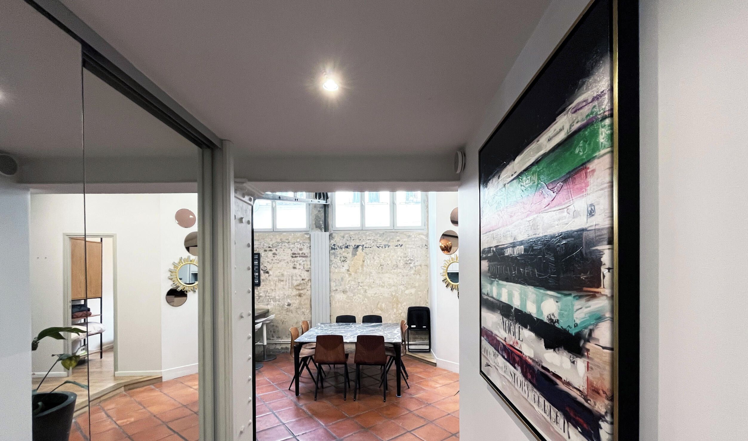 Un ambiente interno con zona pranzo, un'ampia finestra e una parete con superficie strutturata.