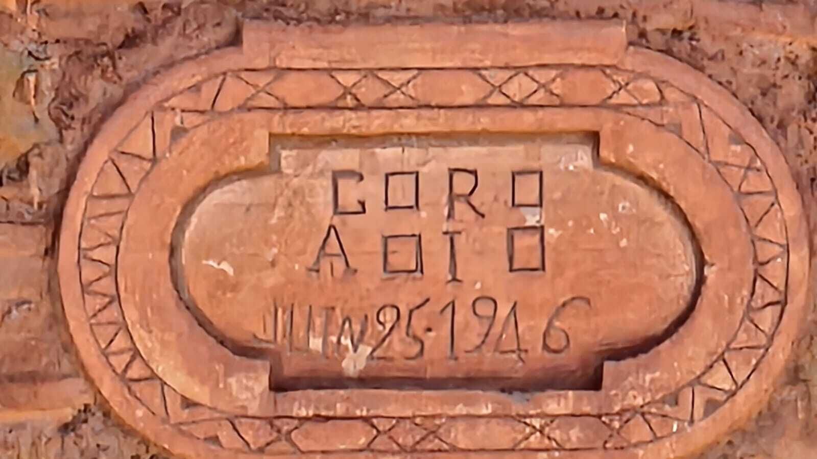 Une plaque de pierre portant une inscription gravée et une date.