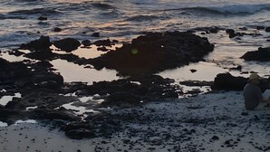 A beach with rocks and a sunset. - Vacation Apartment 'Casa Piña Colada' with Balcony and Wi-Fi (Corralejo)