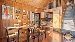 Un intérieur en bois comprenant un coin repas, une cuisine et un escalier.