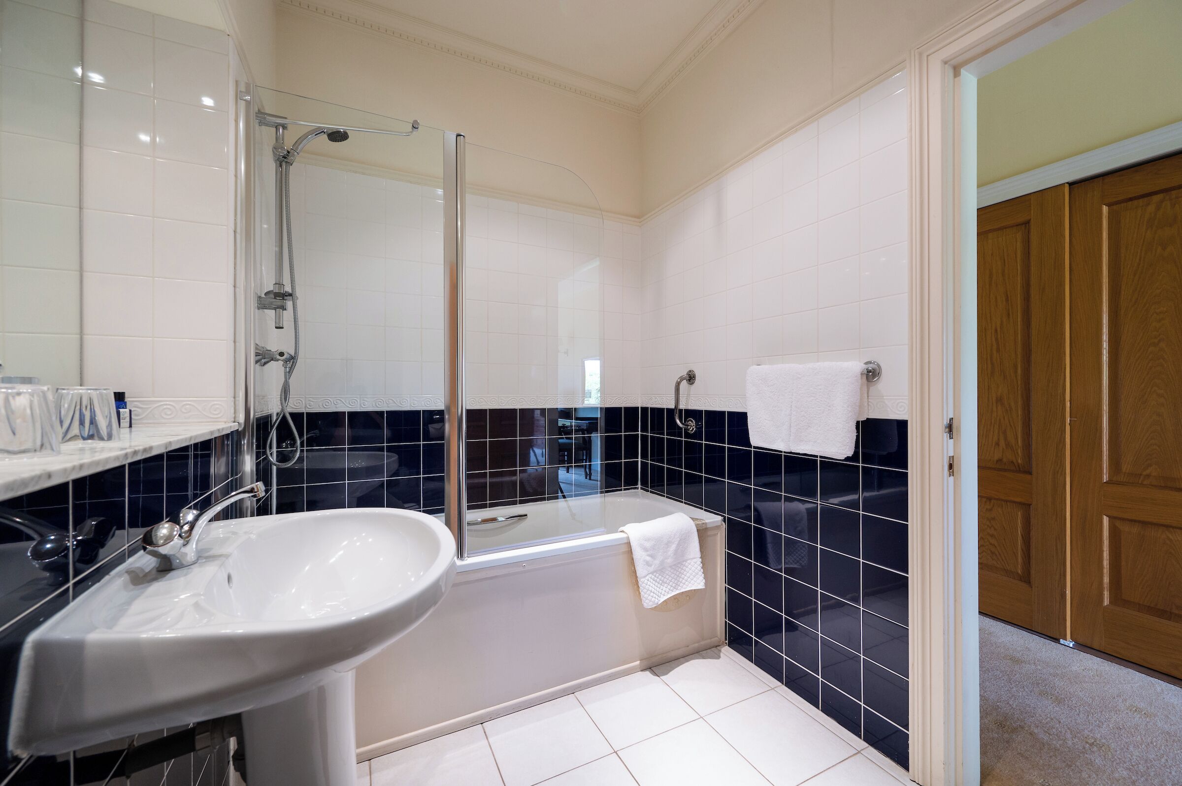 A bathroom with a glass-enclosed shower, a white sink, and a bathtub.