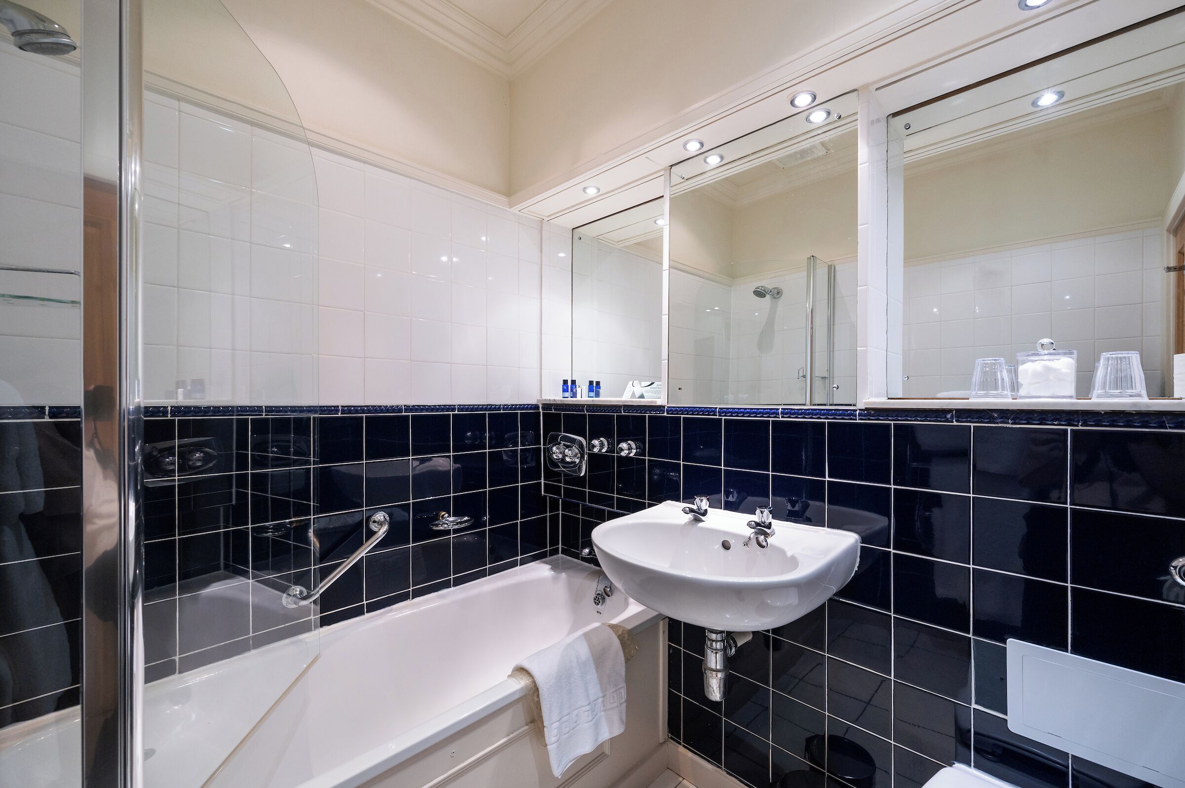 Ein Badezimmer mit einer Badewanne, einem Waschbecken und einem großen Spiegel.