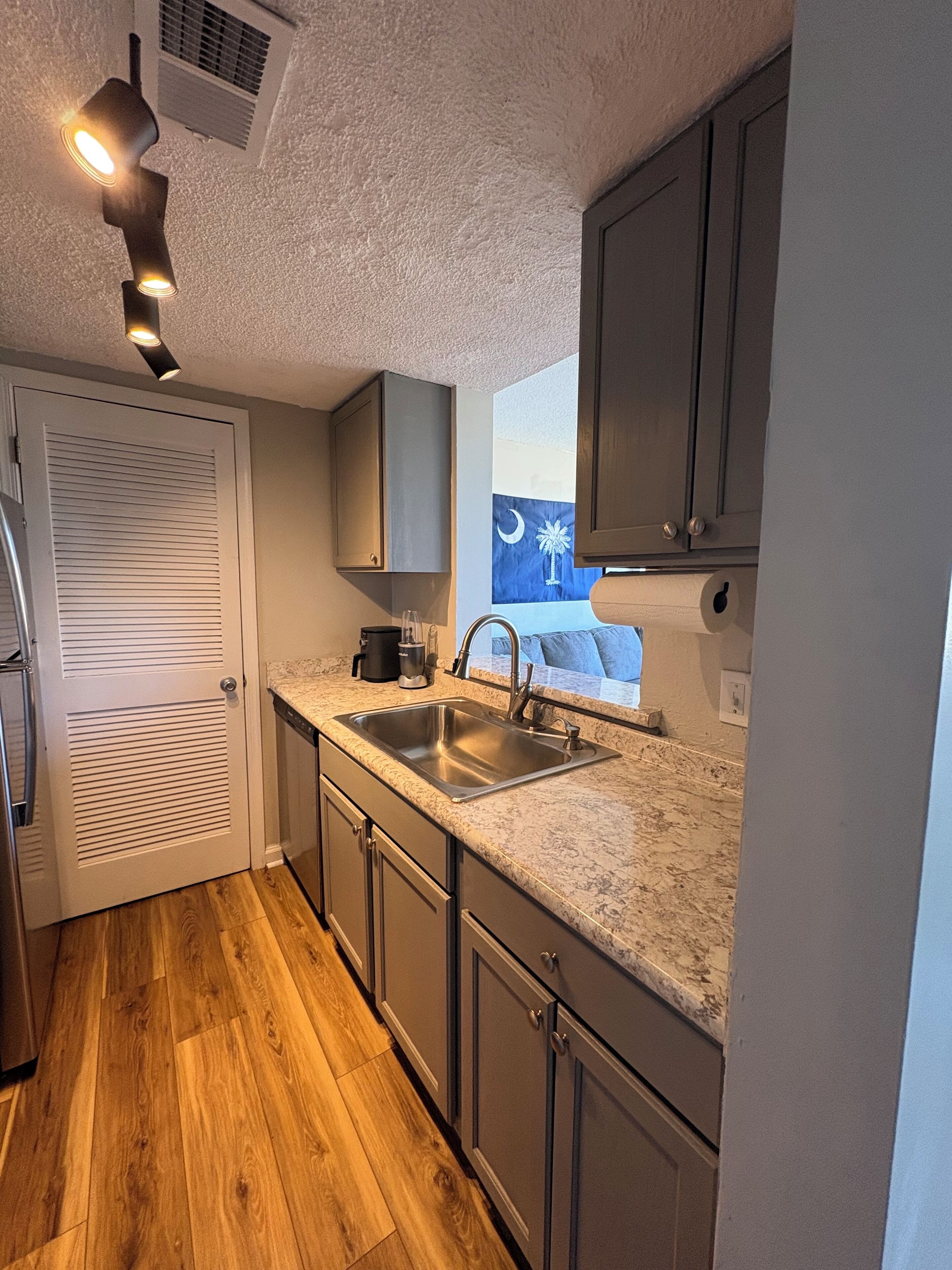 A compact kitchen with a sink, cabinets, and a countertop.