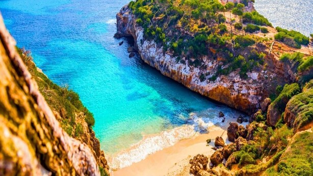 A coastal landscape with a rocky cliff, clear blue waters, and a sandy beach. - Estudio centrico y economico en Conil (Conil de la Frontera)