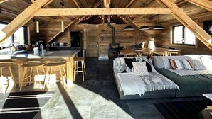 A cozy attic bedroom with a wooden ceiling, a bed with multiple pillows, a small desk, and a window. - CHALET LE CAIRN view of the village Large open spaces 5 minutes from the cable car (Valloire)