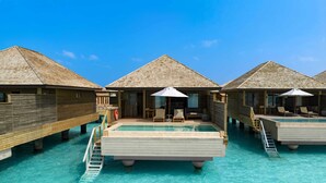 Bungalows sobre el agua con piscina, terraza de madera y sillas reclinables.