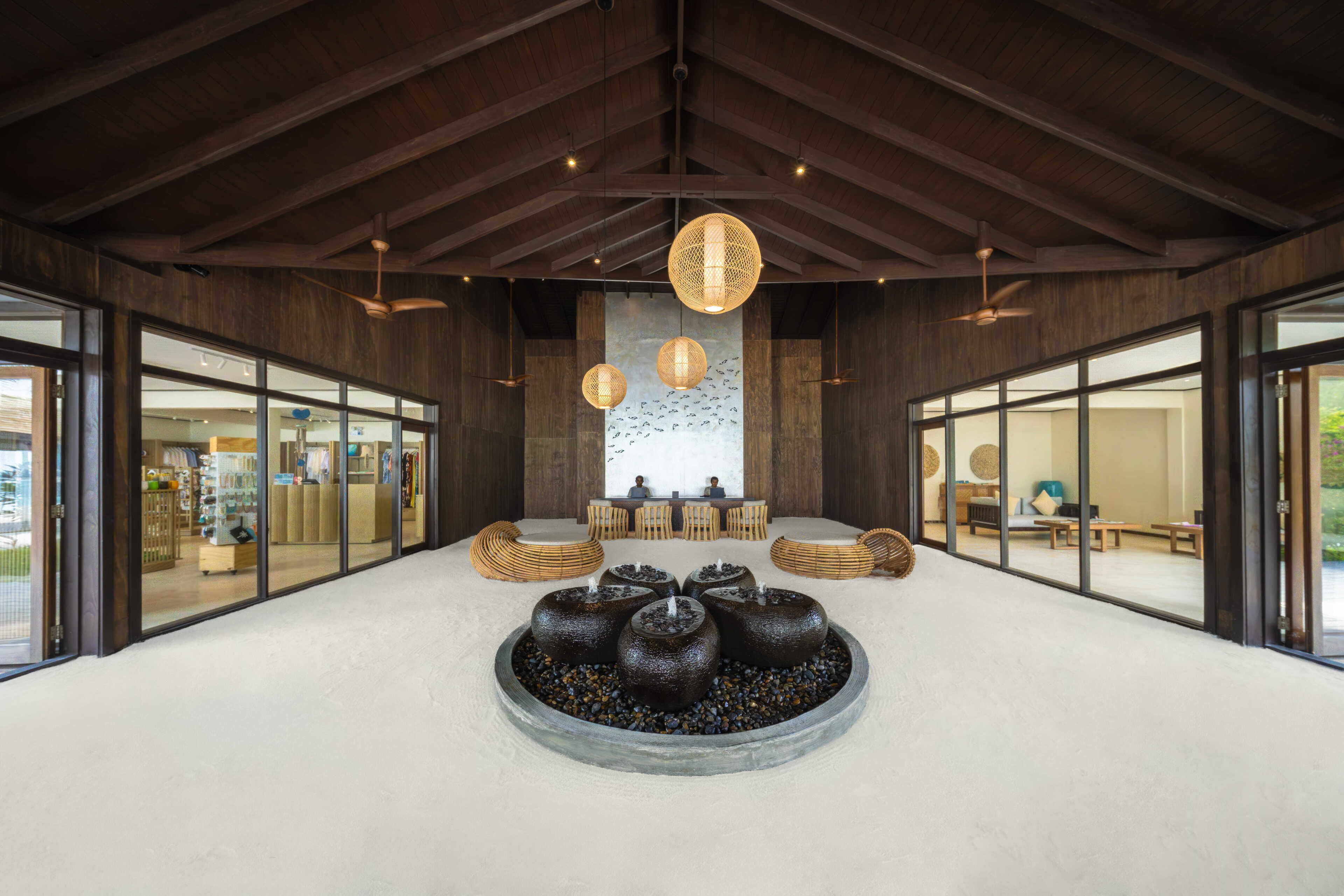 A spacious lobby with a central seating area, large windows, and a ceiling fan.