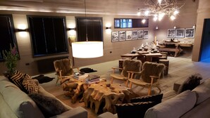 Un salon moderne avec une table basse centrale, des canapés et un coin repas comprenant une table et des chaises en bois.