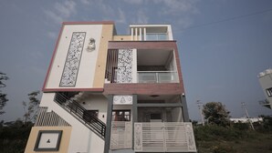 Un edificio de dos plantas con un balcón, una escalera y detalles de metal decorativo.