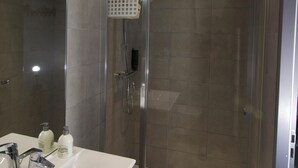 A modern bathroom with a glass-enclosed shower, a white sink, and a mirror. - Relax Studio (Jougne)
