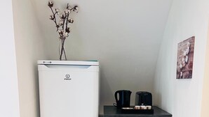 A compact kitchenette with a white refrigerator, a microwave, and a coffee maker on a black countertop. - Relax Studio (Jougne)