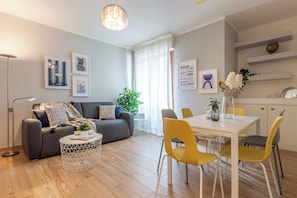 A modern living room with a sofa, coffee table, and dining area with chairs. - Ginger, a stone's throw from the center of Siena with parking space (Siena)