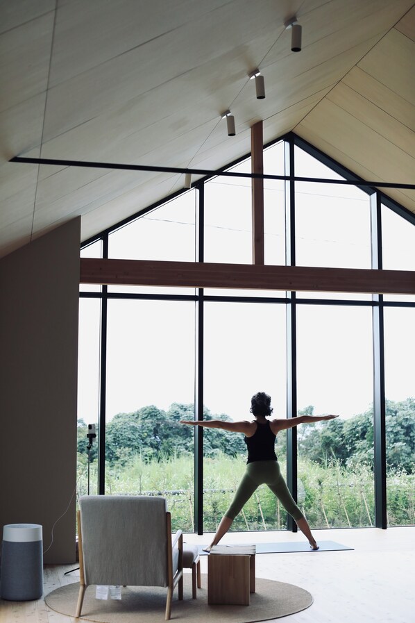 A spacious room with large windows, a yoga mat, and a chair. - 2R Yakushima (Yakushima)