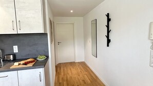 Eine moderne Küche mit weißen Schränken, einer Holz Arbeitsplatte und einem Essbereich mit einem Marmortisch.