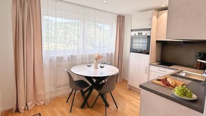 Eine moderne Küche mit Essbereich, Holzboden und Blick ins Freie.