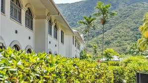 A building with a pathway leading to a mountain view, surrounded by greenery. - Palm Cove Studio Pools Spa Bar (Cairns)