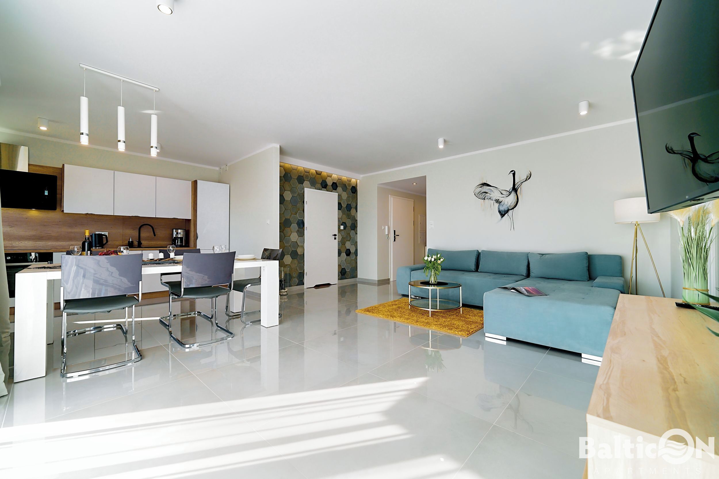 A modern living room with a blue sofa, a coffee table, and a TV.