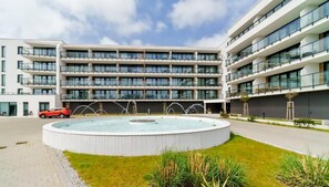 Un hotel moderno a più piani con un cortile centrale e una fontana circolare.
