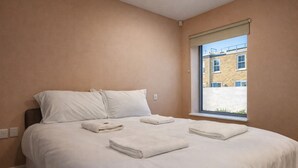 A bedroom with a bed, pillows, and a window. - Still Life Clerkenwell Executive (London)