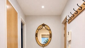 A hallway with wooden flooring, a bench, a mirror, and a coat rack. - Still Life Clerkenwell Executive (London)