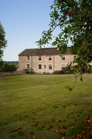 A stone building with multiple windows and a lawn in the foreground. - Manor Farmhouse, Holt, Wiltshire (Near Bath) (Holt)