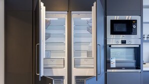 A modern kitchen with a built-in microwave and oven, a double-door refrigerator, and a sleek design.