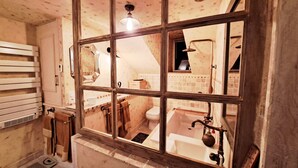 A bathroom with a large window, a bathtub, a toilet, and a sink. - COSY CHAMBER - Air-conditioned SUITE (Sancoins)
