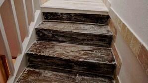 A staircase with a white door at the top, leading to a room labeled "STUDIO". - COSY CHAMBER - Air-conditioned SUITE (Sancoins)