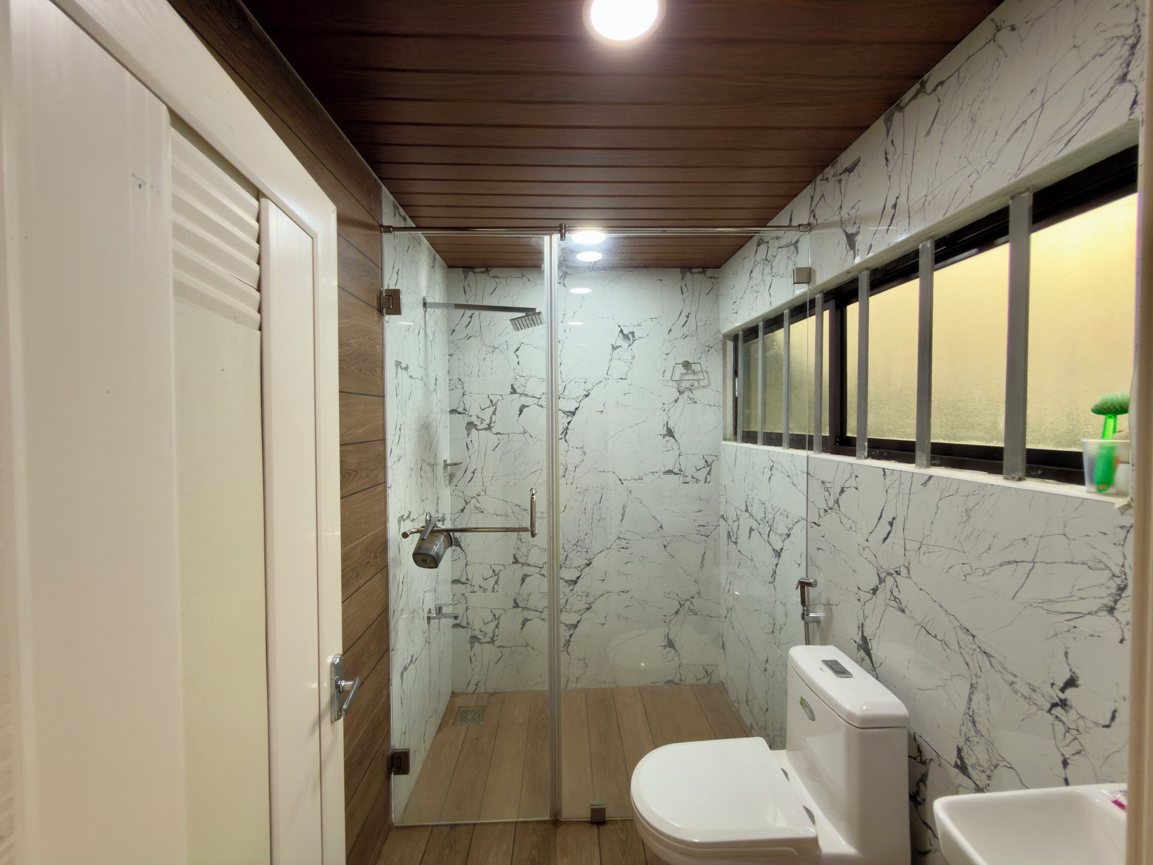 Une salle de bain avec une douche à parois en verre, des toilettes et un lavabo.