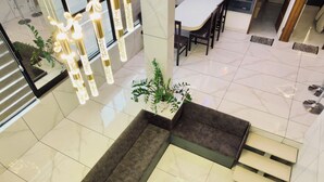 Un interior moderno con un sofá modular, una zona de comedor y una escalera.