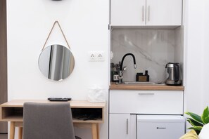 A compact kitchenette with a sink, a coffee maker, and a compact refrigerator. - Athens Luxury Penthouse (Athens)