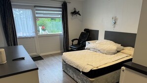 A bedroom with a bed, a chair, a desk, and a window with curtains. - Motel like en suite room, own front door. Secure parking. 1 mile to crewkerne (Crewkerne)