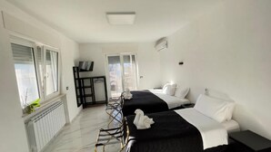 A hotel room with two beds, a desk, and a chair. - Beb Villa Real (Balvano)