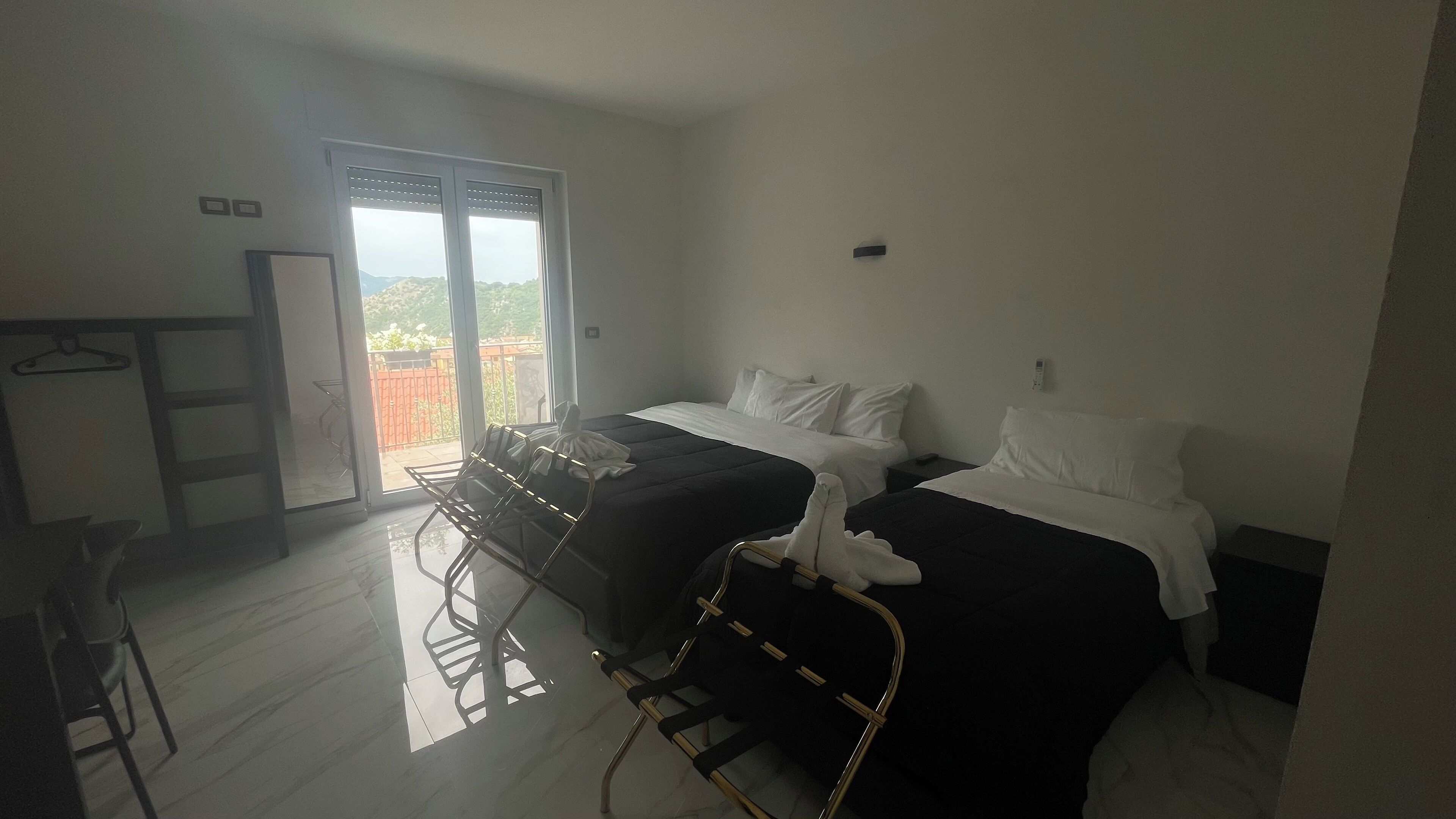 Ett hotellrum med två sängar, ett skrivbord och en stol.