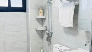 A modern bathroom with a toilet, sink, and shower.