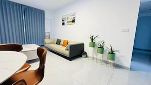 Ein modernes Wohnzimmer mit einer Couch, einem Esstisch und Topfpflanzen.