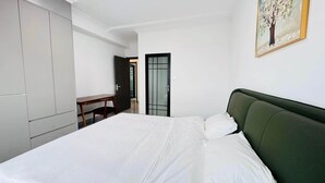 A bedroom with a bed, a desk, and a wardrobe. - Luxury apartment in the heart of the great metropolis of Abidjan (Abidjan)